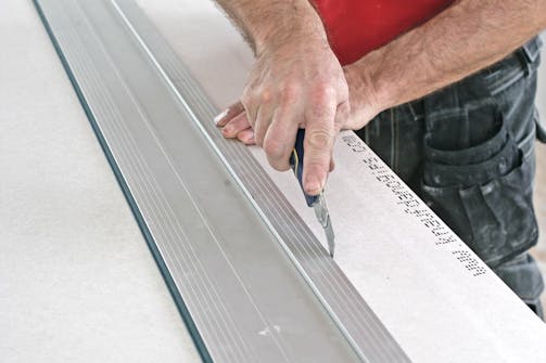 Slik skjæres gipsplater til: Legg en stabel gipsplater opp på to bukker, slik at du får et arbeidsbord. Slik skjæres gipsplater til: Legg en stabel gipsplater opp på to bukker, slik at du får et arbeidsbord.